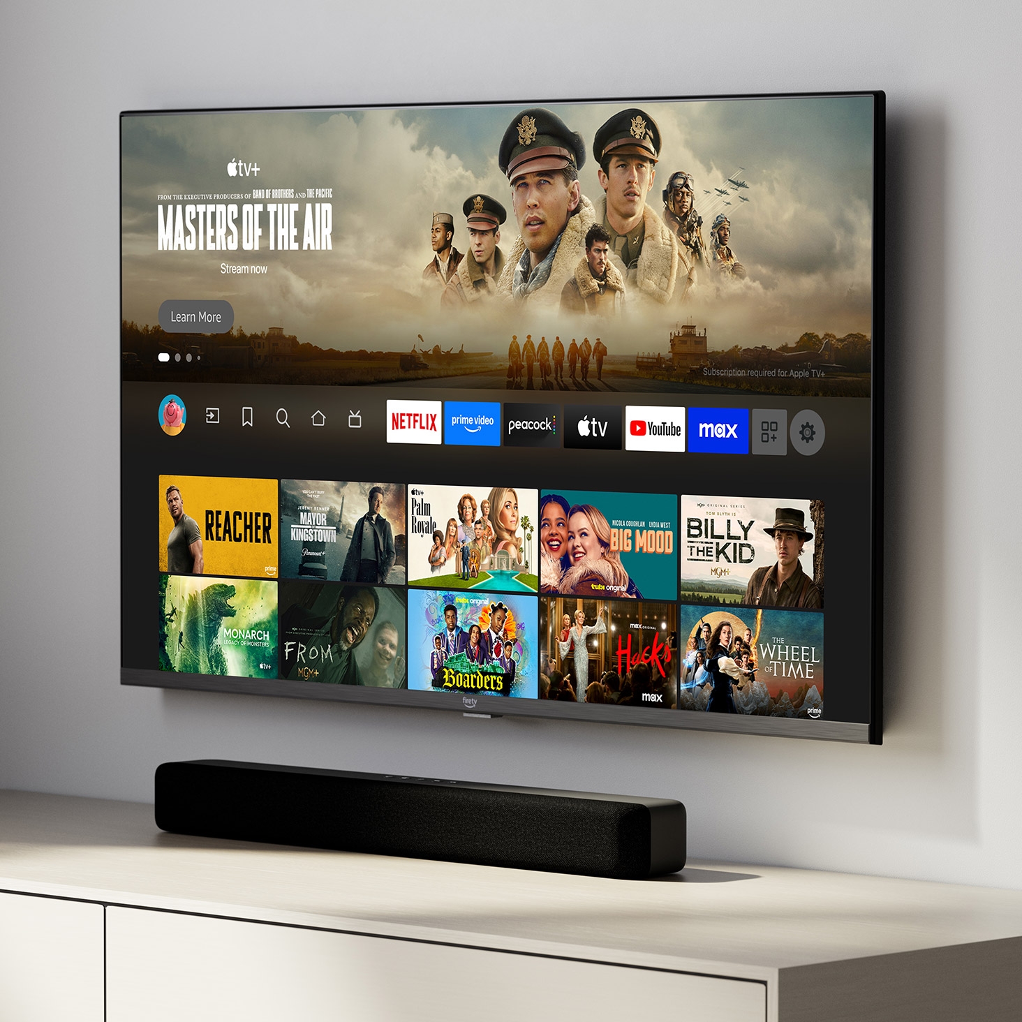 Angled view of the Fire TV 4-Series mounted to the wall above an entertainment center. A soundbar sits directly below the TV. 